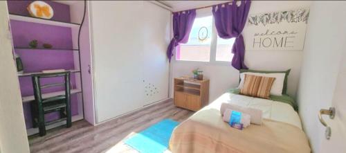 1 dormitorio con 1 cama y una ventana con cortinas moradas en -Malargüe House- en Malargüe