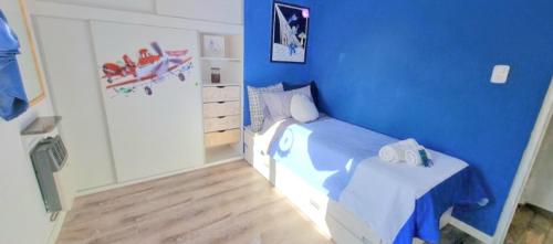 Dormitorio azul con cama y mesa en -Malargüe House- en Malargüe