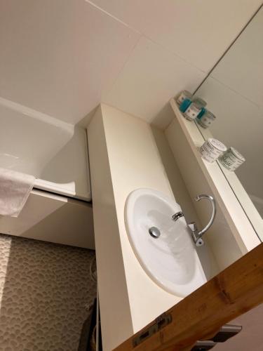 La salle de bains est pourvue d'un lavabo blanc. dans l'établissement Le 104 Miravidi, à Bourg-Saint-Maurice
