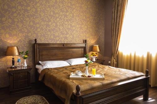 a bedroom with a bed with a tray of food on it at Shah Palace Hotel in Bishkek