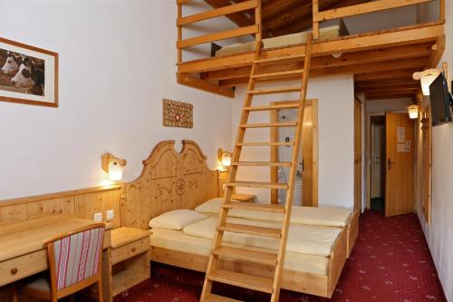 Hôtel Le Relais Alpin في Les Mosses: غرفة مع سرير بطابقين وسلم