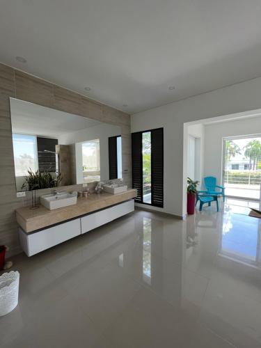 a white bathroom with two sinks and a large mirror at Casa Campestre en Condominio Lagos Del Peñon in Girardot