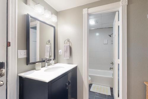 uma casa de banho com um lavatório, um espelho e uma banheira em Bella Paradiso 04 em Eureka Springs