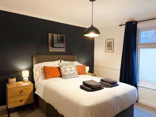 Schlafzimmer mit einem Bett mit schwarzer Wand in der Unterkunft 3 Bedroom home close to town centre with WiFi & garden in Royal Tunbridge Wells