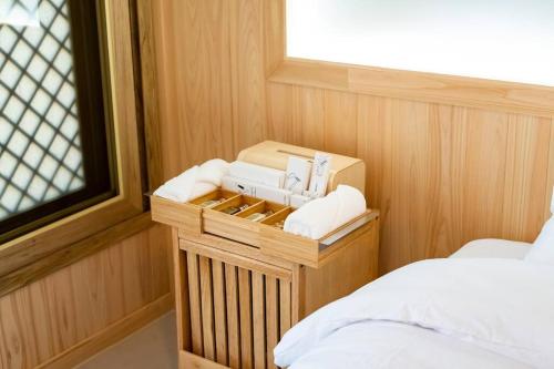 ヨス市にあるElon Hanok Pensionのベッド1台とミシンが備わる小さな客室です。