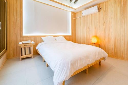 a bedroom with a large white bed in a room at Ellon Hanok Pension in Yeosu