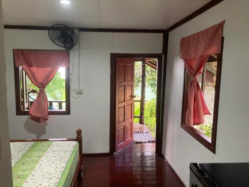 a room with two beds and an open door at Easy Life Bungalows in Haad Yao