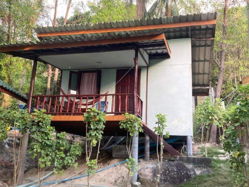 a small house with a balcony in the woods at Easy Life Bungalows in Haad Yao