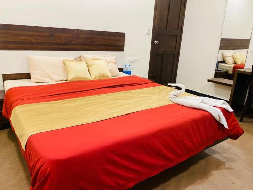 a large bed with a red and yellow blanket at Alice Lake Promise in Alleppey