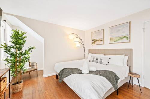 Un dormitorio blanco con una cama y una planta en Tranquil on Taro, en Phoenix