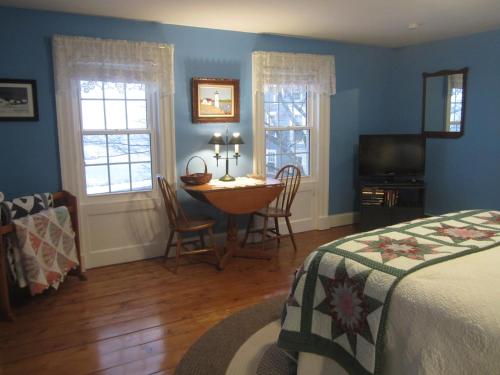 1 dormitorio con 1 cama, mesa y sillas en Grand Oak Manor Bed and Breakfast, en Granville Ferry