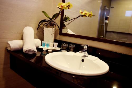 a bathroom with a sink and a mirror at Aura One Hotel in Baguio