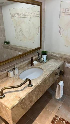 uma casa de banho com um lavatório e um espelho grande em SuiteSEA em Eilat