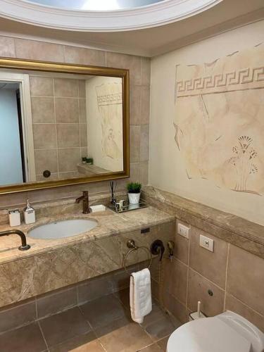 uma casa de banho com um lavatório, um WC e um espelho. em SuiteSEA em Eilat