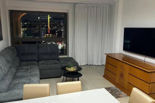uma sala de estar com um sofá e uma televisão de ecrã plano em SuiteSEA em Eilat