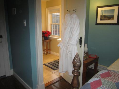 a bedroom with a robe hanging on the door at Grand Oak Manor Bed and Breakfast in Granville Ferry