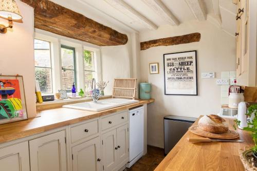 a kitchen with a sink and a counter top at Charming 2BD Cottage in the Heart of Kingham! in Kingham