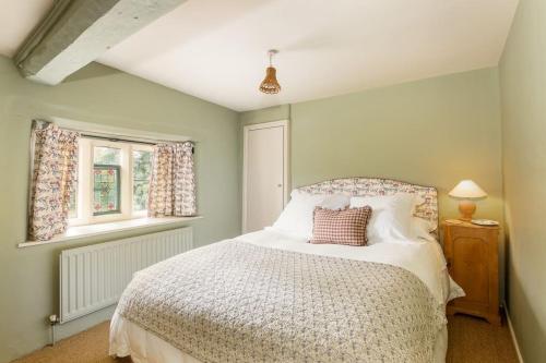 A bed or beds in a room at Charming 2BD Cottage in the Heart of Kingham!