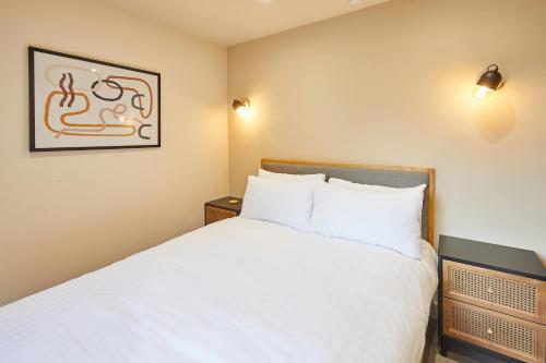 Un dormitorio con una cama blanca y una foto en la pared en Host & Stay - No.33, en Tynemouth