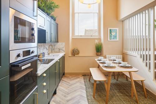a kitchen with a table and a kitchen with blue cabinets at Host & Stay - No.33 in Tynemouth