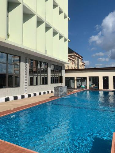 a large swimming pool in front of a building at De Silver Green Luxury Hotel in Abuja