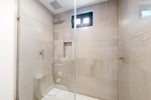 a bathroom with a shower with a glass door at Seven Boutique Unit #36 in Cancún
