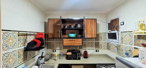 a kitchen with wooden cabinets and a counter top at shehab - residence Hotel apartment in Cairo