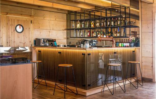 un bar con taburetes en una habitación con paredes de madera en Pet Friendly Apartment In Jezierzany With House A Panoramic View, en Jezierzany