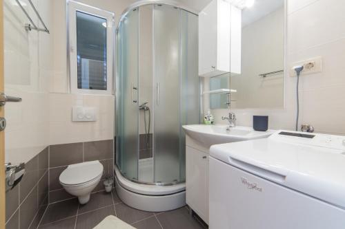 ein Badezimmer mit Dusche, Toilette und Waschbecken in der Unterkunft Apartments Sunrise in Brist