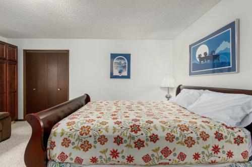 a bedroom with a bed with a flowered blanket at Skiview #103 in Girdwood