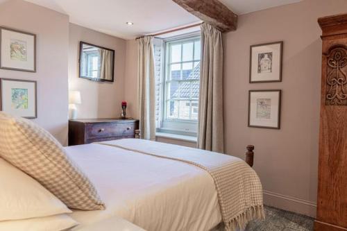 een slaapkamer met een bed en een raam bij Luxury Bolthole in the Heart of the Cotswolds in Malmesbury