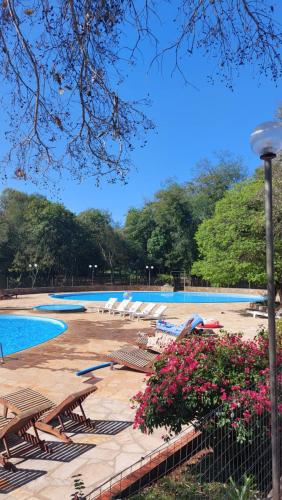 Hohenau的住宿－Casa de huéspedes Mariposa en manantial countryclub，公园里一个带椅子和鲜花的游泳池