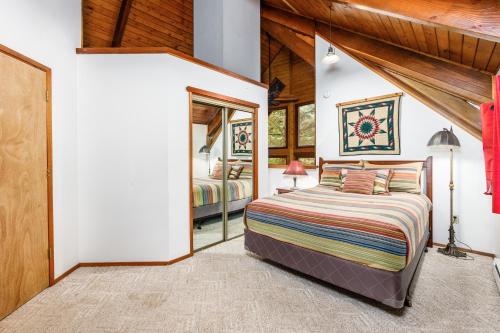 1 dormitorio con cama y espejo en Vail Chalet, en Girdwood