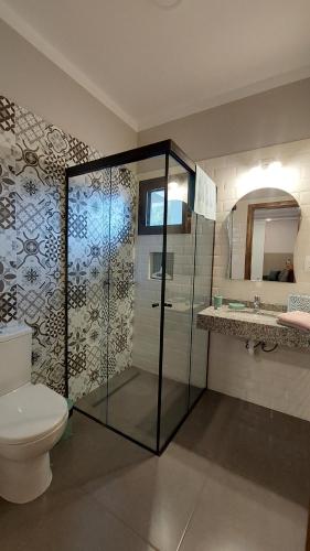 a bathroom with a glass shower and a toilet at Casa de huéspedes Mariposa en manantial countryclub in Hohenau