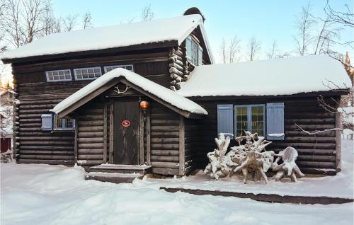 Lovely Home In Vemdalen With Sauna في فيمدالين: كابينة خشبية في الثلج مع تمثال في الأمام