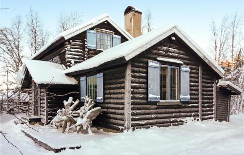 a log cabin with a statue in the snow at Lovely Home In Vemdalen With Sauna in Vemdalen