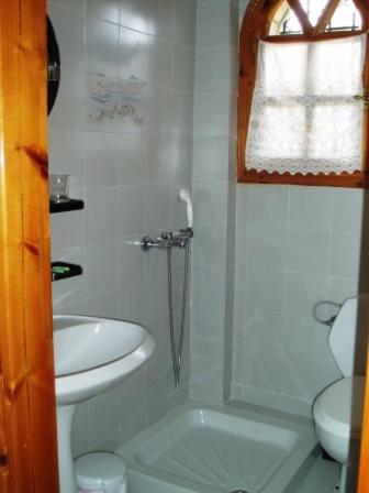 a white bathroom with a sink and a toilet at Pantheon Studios & Apartments in Limenaria