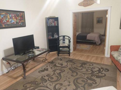ein Wohnzimmer mit einem TV, einem Tisch und einem Bett in der Unterkunft Loft Apartment w River Views in Salisbury