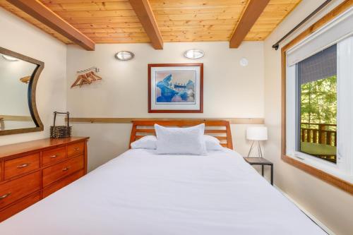 a bedroom with a large white bed and a window at Moose Meadow Chalet in Girdwood
