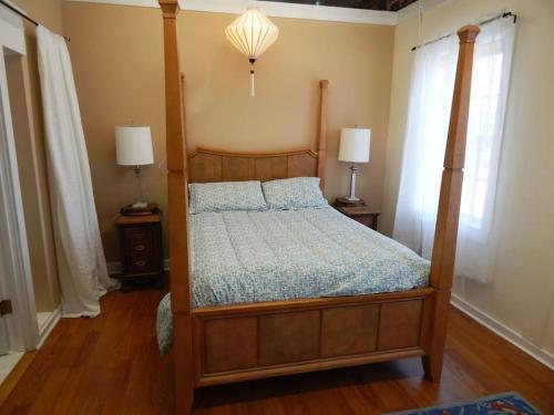 a bedroom with a four poster bed with two lamps at 2 bed, 1 bath riverfront loft in Salisbury