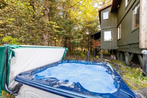 a jacuzzi tub in the backyard of a house at Moose Meadow Chalet in Girdwood