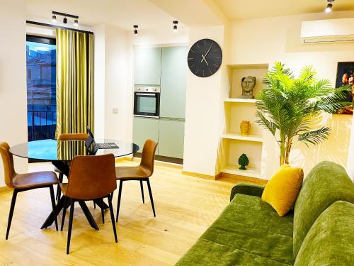 ein Wohnzimmer mit einem grünen Sofa und einem Tisch in der Unterkunft Agrigento Boutique Apartments in Agrigento