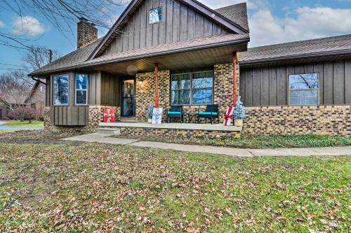 a brick house with a porch with two chairs at Clio Apt on 3 Acres, 14 Mi to Frankenmuth! in Birch Run