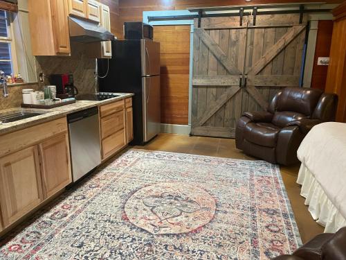 a kitchen with a sliding barn door and a leather chair at Cajun-Get Away in Breaux Bridge