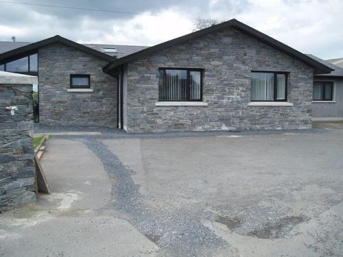 a stone house with a driveway in front of it at 'Little Acre' perfect for business or pleasure in Portadown