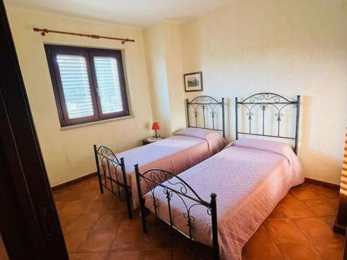 2 camas individuales en un dormitorio con ventana en Holiday home in Francavilla di Sicilia, en Francavilla di Sicilia