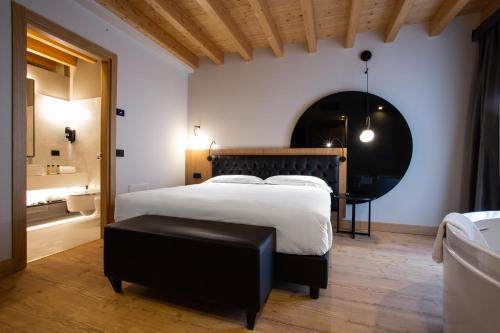 a bedroom with a large bed and a black stool at Hotel Master in Brescia