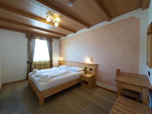 Agritur Sandro في Sporminore: غرفة نوم بسرير كبير وطاولة