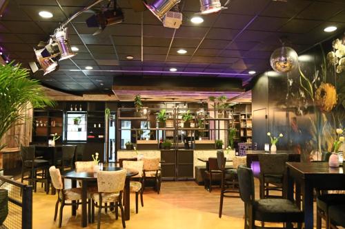 un restaurante con mesas, sillas y techos púrpuras en Glamplodge met privé sanitair en Blesdijke