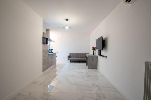 a hallway with white walls and a living room with a couch at VILLA CLIPPER in Juan-les-Pins